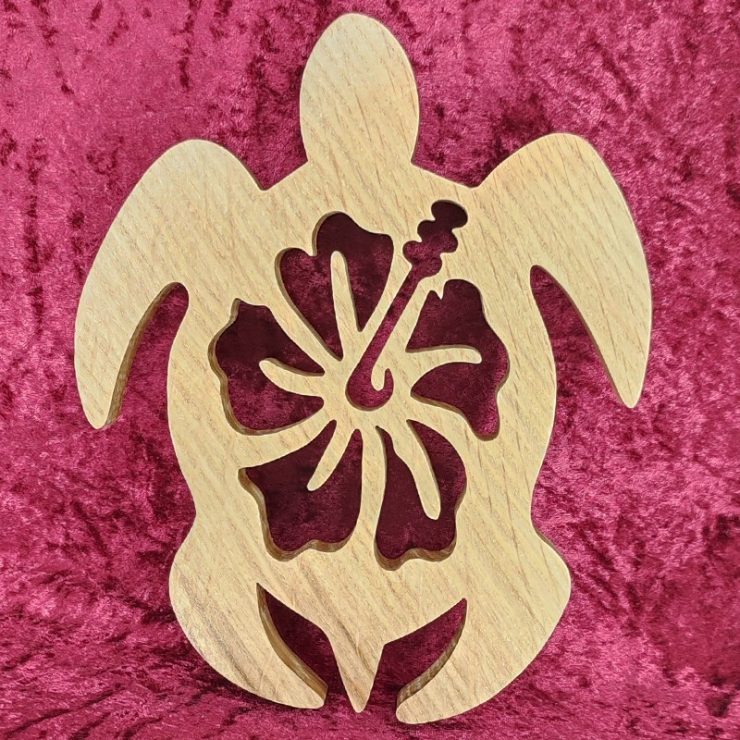 dessous de plat en bois d'une tortue avec une fleur d'hibiscus
